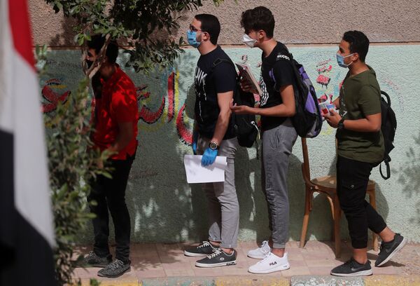 Учащиеся старших классов в защитных масках в первый день выпускных экзаменов в Каире, Египет - Sputnik Узбекистан