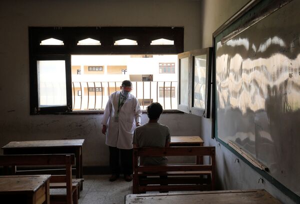 Врач наблюдает за учеником в первый день выпускных экзаменов в Каире, Египет - Sputnik Узбекистан