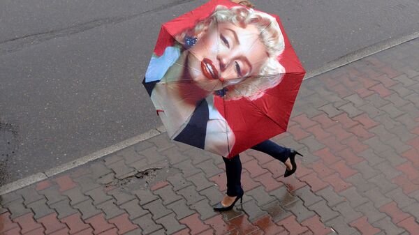 Женщина с зонтом на улице во время ливня в Красноярске - Sputnik Ўзбекистон