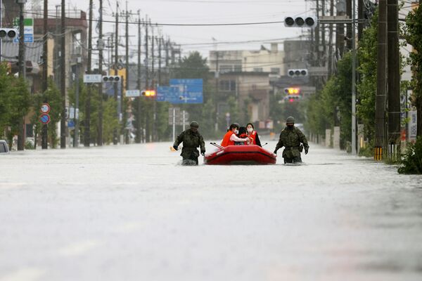 Количество жертв наводнения достигло 76 человек. На фото - служащие Сил самообороны Японии спасают местных жителей от наводнения на юге страны в городе Омута, префектура Фукуока - Sputnik Узбекистан