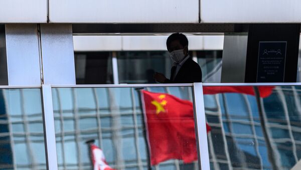 Мужчина проходит мимо отражения китайского флага - Sputnik Узбекистан