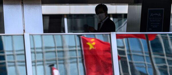 Мужчина проходит мимо отражения китайского флага - Sputnik Узбекистан