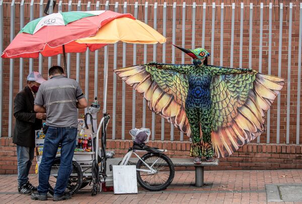 Человек в костюме колибри во время акции, призывающей соблюдать меры безопасности во время эпидемии коронавируса, Богота. - Sputnik Узбекистан