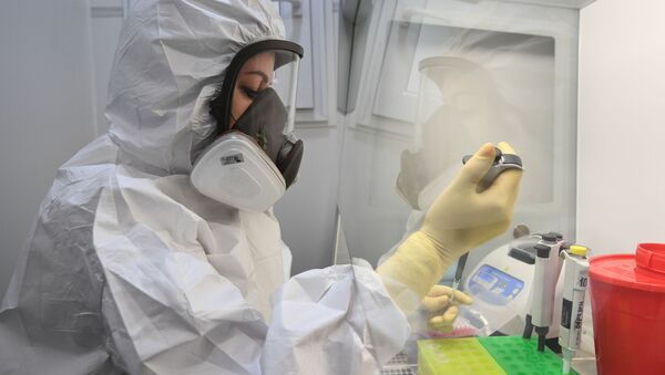 Медицинский работник демонстрирует работу передвижной лаборатории по диагностике и профилактике новой коронавирусной инфекции COVID-19 - Sputnik Узбекистан