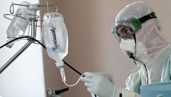 Медицинский сотрудник устанавливает капельницу в стационаре для больных с коронавирусной инфекцией - Sputnik Ўзбекистон