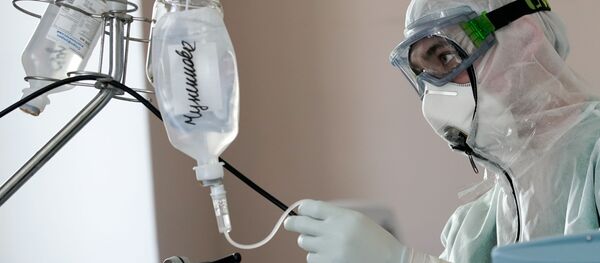 Медицинский сотрудник устанавливает капельницу в стационаре для больных с коронавирусной инфекцией Медицинский сотрудник устанавливает капельницу в стационаре для больных с коронавирусной инфекцией - Sputnik Ўзбекистон