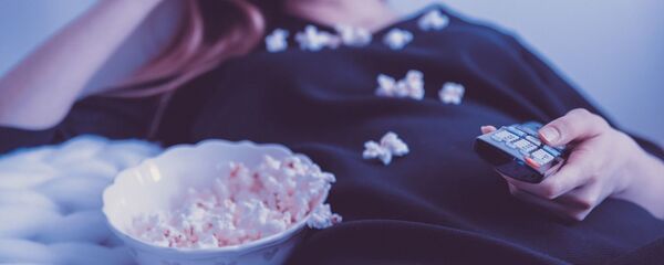 Девушка в постели ест попкорн и держит пульт. Архивное фото Девушка в постели ест попкорн и держит пульт. Архивное фото - Sputnik Ўзбекистон