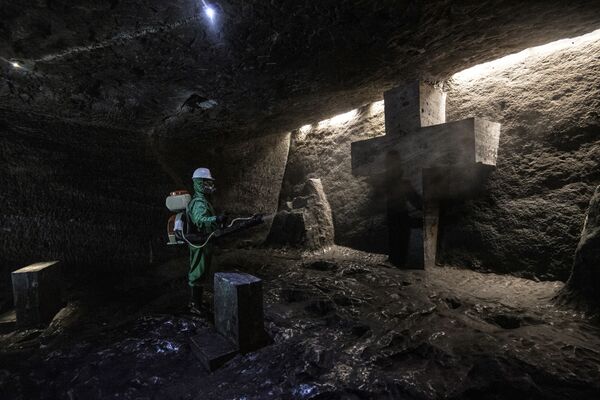 Рабочий дезинфицирует Соляной собор Сипакира, подземную церковь, встроенную в соляную шахту, Колумбия. - Sputnik Узбекистан