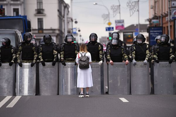 Участница несанкционированной акции оппозиции Марш единства и сотрудники милиции на улице в Минске. - Sputnik Узбекистан