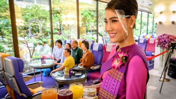 Стюардесса Таиландских авиалиний во время обслуживания посетителей ресторана в самолете в Бангкоке  - Sputnik Узбекистан