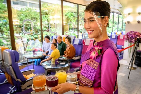 Стюардесса Таиландских авиалиний во время обслуживания посетителей ресторана в самолете в Бангкоке  - Sputnik Узбекистан