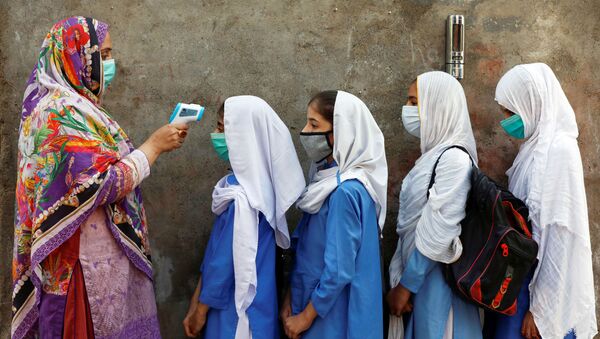 Проверка температуры у учеников перед входом в класс в Пешаваре, Пакистан - Sputnik Узбекистан