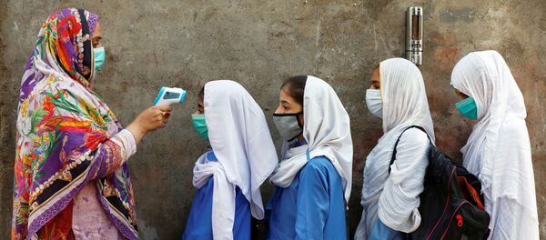 Проверка температуры у учеников перед входом в класс в Пешаваре, Пакистан Проверка температуры у учеников перед входом в класс в Пешаваре, Пакистан - Sputnik Узбекистан