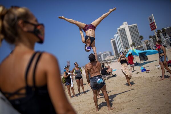 Акробаты выступают во время акции протеста против решения правительства закрыть пляжи из-за пандемии коронавируса в Тель-Авиве, Израиль. - Sputnik Узбекистан