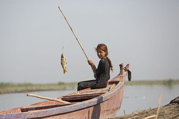 Девочка ловит рыбу недалеко от города Басра, Ирак. - Sputnik Узбекистан