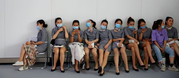 Персонал в масках во время отдыха на Пекинском международном автошоу Персонал в масках во время отдыха на Пекинском международном автошоу - Sputnik Ўзбекистон