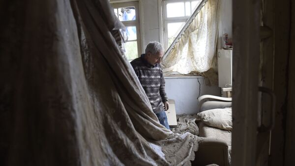 Местный житель показывает комнату пострадавшего дома в городе Мартуни (центр Мартунинского района самопровозглашенной Нагорно-Карабахской Республики) после обстрелов - Sputnik Узбекистан