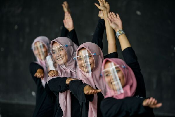 Девушки в защитных масках для лица во время тренировки в художественном и культурном центре в Банда-Ачехе, Индонезия. - Sputnik Узбекистан