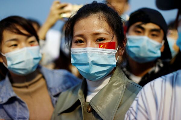 Люди в масках на церемонии поднятия флага на площади Тяньаньмэнь в честь 71-й годовщины основания КНР. - Sputnik Узбекистан