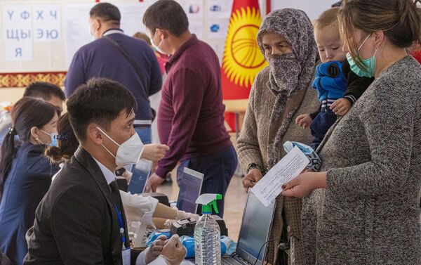 Избиратели и член избирательной комиссии на избирательном участке в городе Бишкек.  - Sputnik Ўзбекистон