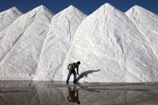 Рабочий соляного завода Коюнджу сгребает большие груды соли на турецком озере Туз в Анкаре. - Sputnik Узбекистан