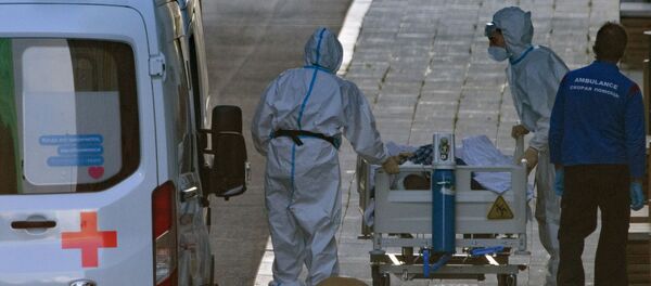 Медицинские работники везут на каталке пациентку, доставленную бригадой скорой медицинской помощи, в здание карантинного центра в Коммунарке Медицинские работники везут на каталке пациентку, доставленную бригадой скорой медицинской помощи, в здание карантинного центра в Коммунарке - Sputnik Ўзбекистон