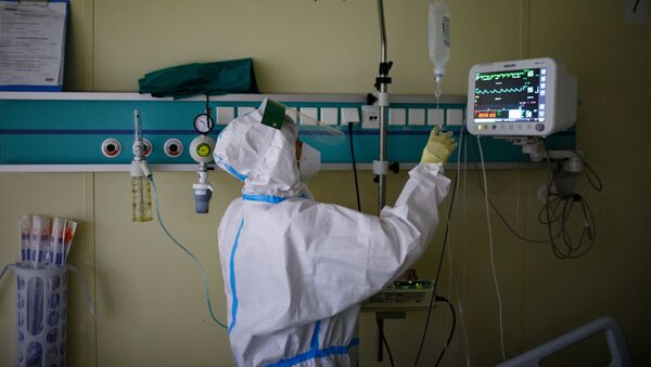 Медицинский работник оказывает помощь пациенту с COVID-19 - Sputnik Ўзбекистон