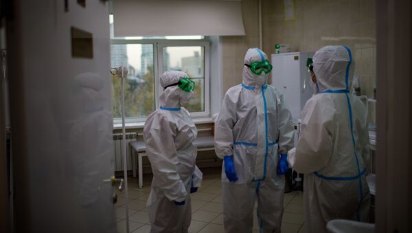 Медицинские работники оказывают помощь пациенту с COVID-19 - Sputnik Узбекистан