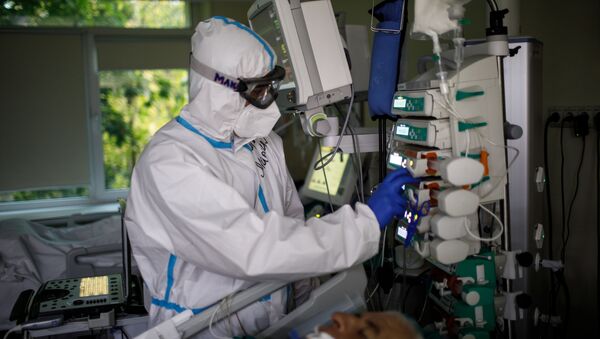 Медицинский работник оказывает помощь пациенту с COVID-19  - Sputnik Узбекистан