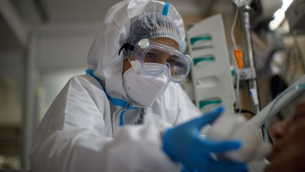 Медицинский работник оказывает помощь пациенту с COVID-19  - Sputnik Узбекистан
