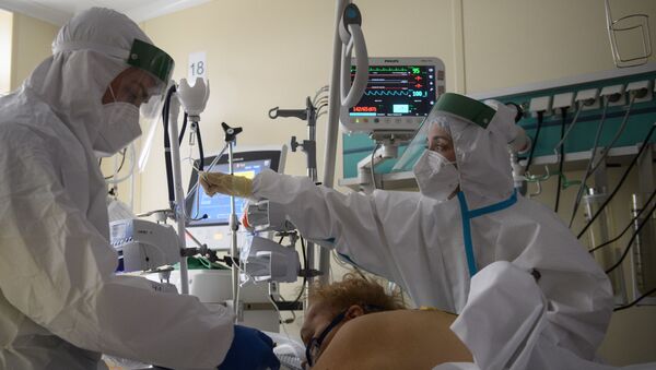 Медицинские работники оказывают помощь пациенту с COVID-19 - Sputnik Ўзбекистон