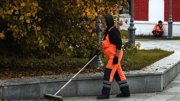 Женщина убирает опавшие с деревьев - Sputnik Ўзбекистон