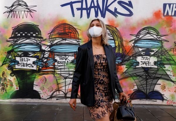 Девушка в маске напротив граффити в Лондоне  - Sputnik Ўзбекистон