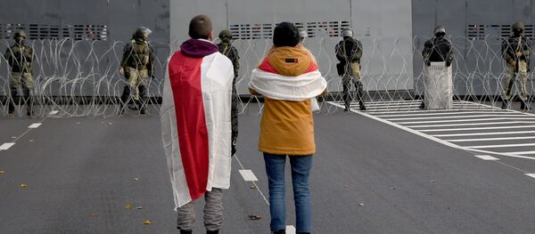 Участники несанкционированной властями акции протеста Партизанский марш у оцепления правоохранительных сил в Минске - Sputnik Узбекистан