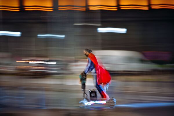 Мужчина в костюме супермена едет на скутере по улице Бухареста, Румыния - Sputnik Ўзбекистон