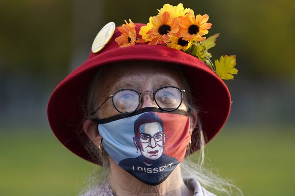 Женщина в маске с портретом судьи Верховного суда Рут Бейдер Гинзбург во время акции протеста в Портленде - Sputnik Узбекистан