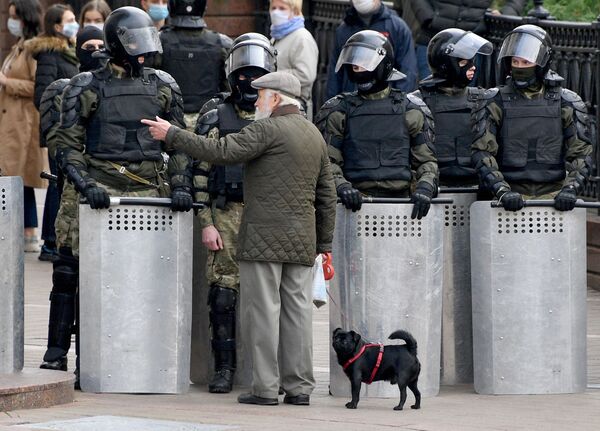 Мужчина разговаривает с сотрудниками милиции во время акции протеста оппозиции Народный ультиматум в Минске - Sputnik Узбекистан