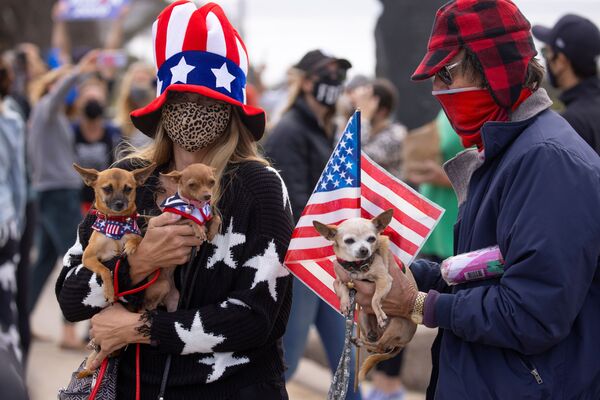 Люди со своими питомцами праздную победу Джо Байдена на президентских выборах в США, Кардифф, Калифорния - Sputnik Узбекистан