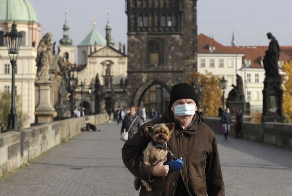 Мужчина в защитной медицинской маске на Карловом мосту в Праге, Чехия - Sputnik Узбекистан