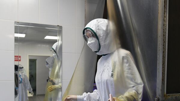 Медицинский работник в отделении дезинфекции госпиталя COVID-19 - Sputnik Ўзбекистон