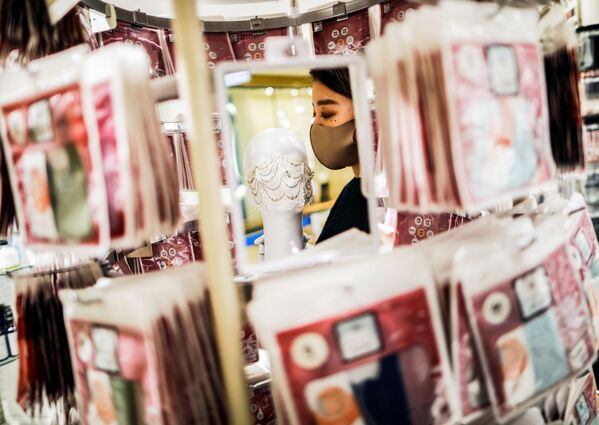 Сотрудник магазина держит маску с драгоценными камнями  в Токио  - Sputnik Узбекистан