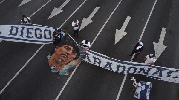 Болельщики с баннером во время скорби по Диего Марадоне в Аргентине  - Sputnik Узбекистан