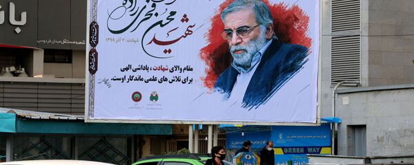 Автомобили проезжают мимо плаката с изображением ученого-ядерщика Мохсена Фахризаде в Тегеране, Иран - Sputnik Узбекистан