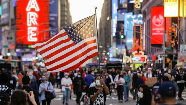 Мужчина с флагом США на Таймс-сквер в Нью-Йорке - Sputnik Узбекистан
