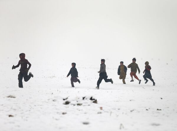 Афганские мальчики играют во время снегопада в Кабуле - Sputnik Ўзбекистон
