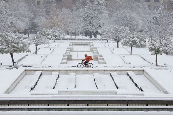 Мужчина на велосипеде во время снегопада в Софии, Болгария - Sputnik Ўзбекистон