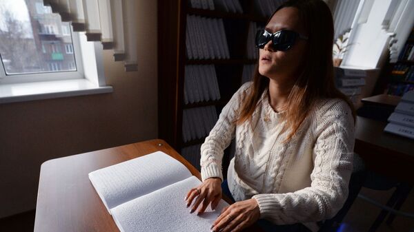 Незрячая посетительница читает с помощью рук книгу - Sputnik Узбекистан