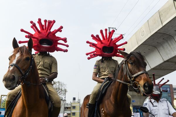 Индийские полицейские в шлемах в форме модели коронавируса во время локдауна в Секундерабаде - Sputnik Узбекистан