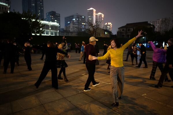 Люди танцуют ночью парке спустя год после вспышки COVID-19 в Ухане - Sputnik Ўзбекистон