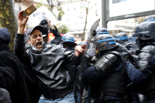 Участник протеста и полицейские в Париже. - Sputnik Узбекистан